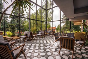 Un espacio interior amplio con ventanas grandes, muebles de madera y un piso con diseño.