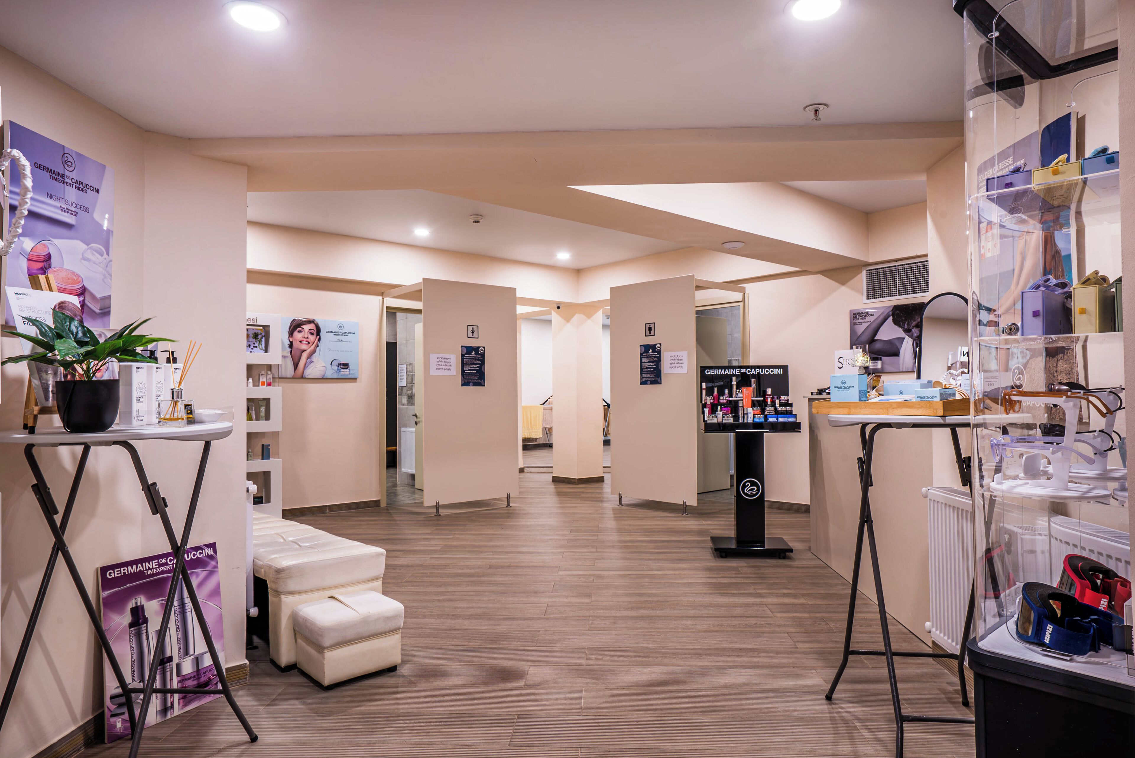A modern spa with a clean, minimalist design, featuring a reception area, a massage room, and a display of spa products.