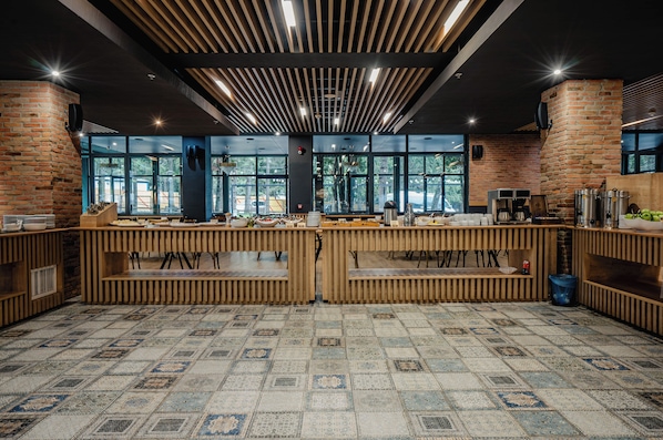 Un restaurant moderne avec un mur en briques, de grandes fenêtres et un sol à motifs.