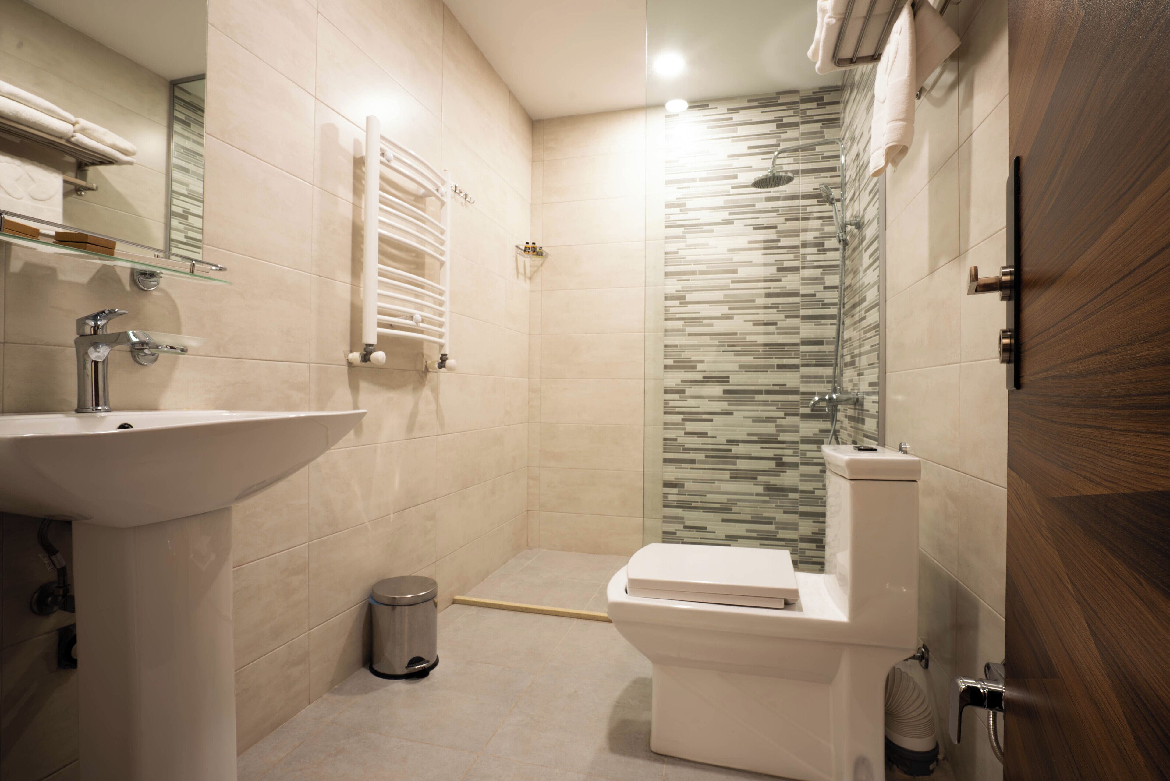 A modern bathroom with a sink, toilet, and shower.