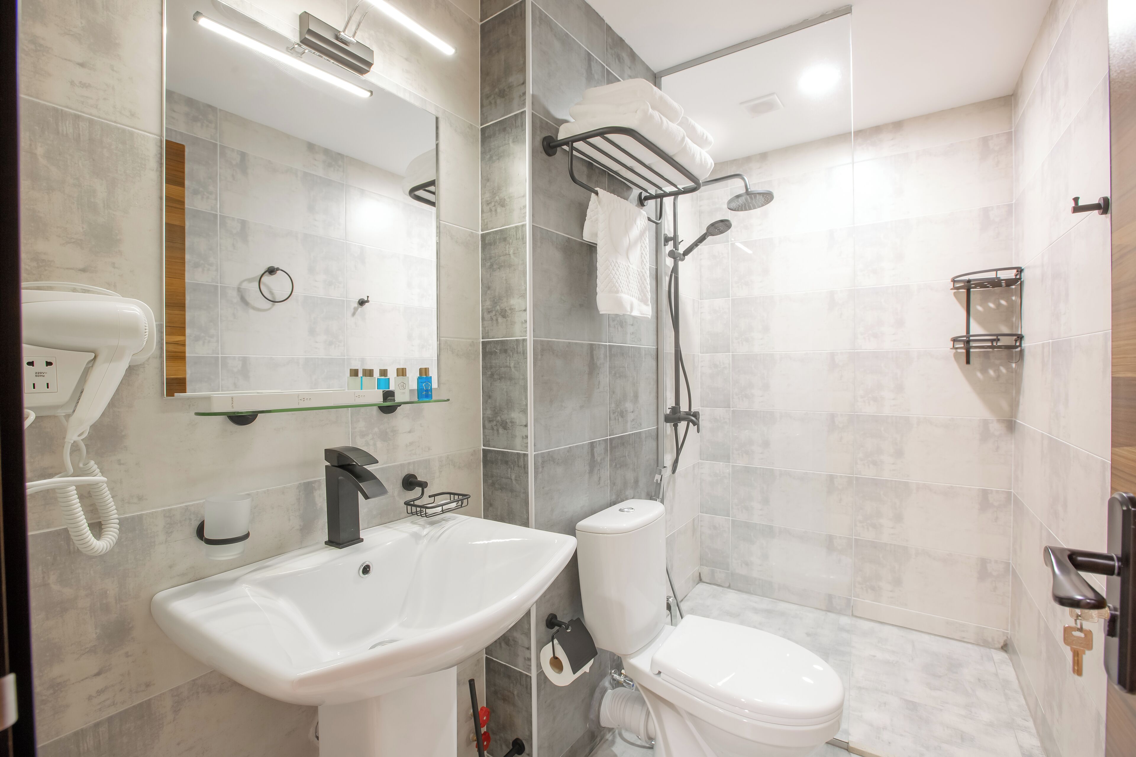 A modern bathroom with a sink, toilet, and shower.