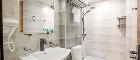 A modern bathroom with a sink, toilet, and shower.