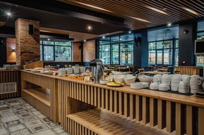 A modern cafe with a wooden counter, seating area, and large windows.