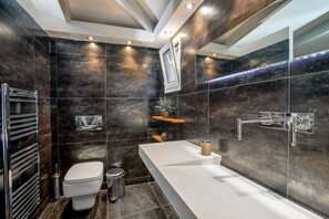 A modern bathroom with a large white sink, a chrome faucet, and a toilet. - Family villa (Ag. Marina)