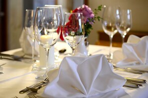 A table set for dining with clear glassware, white napkins, and a candle. - Gasthof Wachter (Gaal)