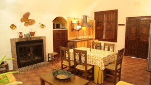 Un saló tranquil amb una llar de foc, taula de dinar i armaris de fusta.