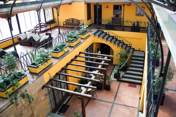 A multi-level interior with a staircase, seating areas, and potted plants. - Hotel Le Bougainviller (Kampala)