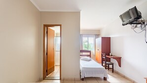 A hotel room with two single beds, a desk, a chair, and a television mounted on the wall. - OYO Hotel Vila Rica, Ribeirão Preto (Ribeirão Preto)