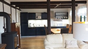 Een gezellige woonkamer met een witte bank, een houten salontafel en een open haard.