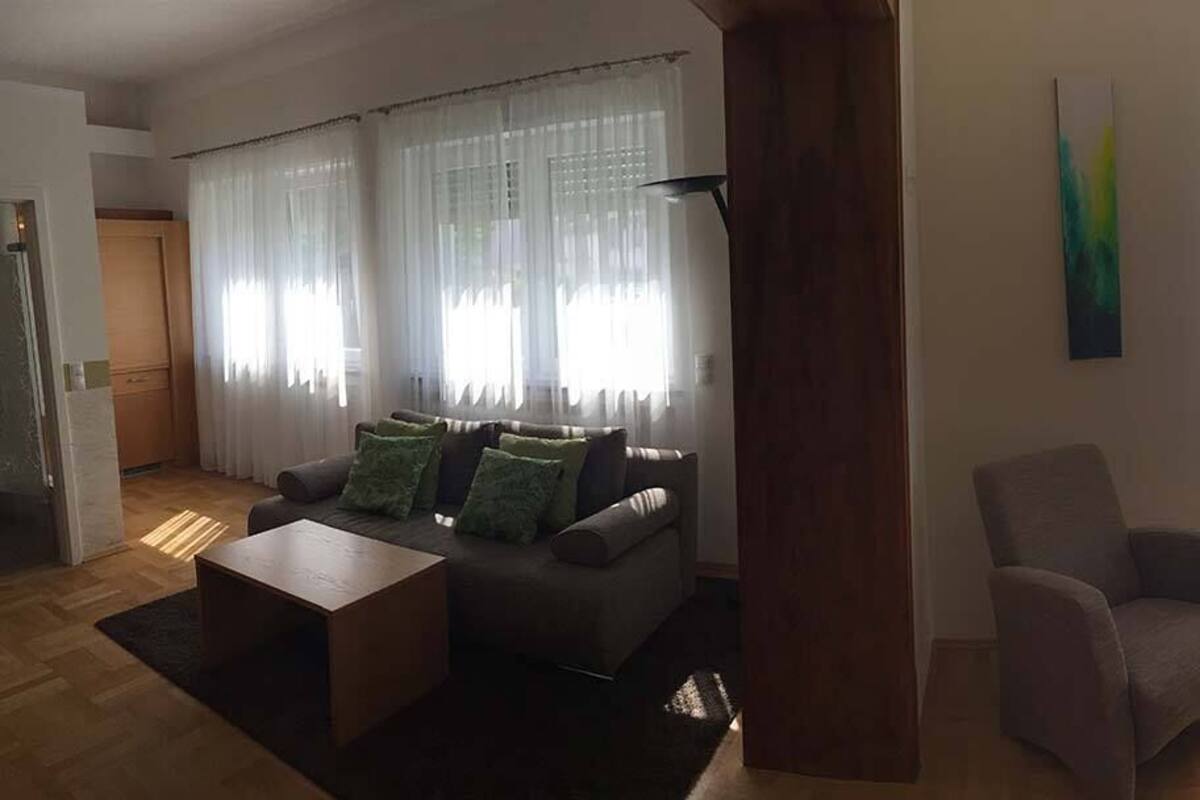 Habitació d'hotel amb un llit, una cadira, un sofà i una taula petita.