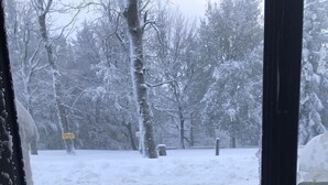 Une scène hivernale en plein air, avec une porte donnant sur un espace enneigé.