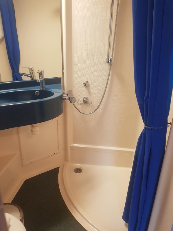 Une salle de bain avec un lavabo, un miroir et une douche.