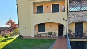 A two-story building with a paved walkway leading to the entrance. - B&B Aria (Sarzana)