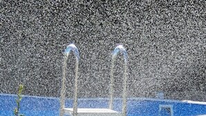 A swimming pool with two clear water fountains and a blue deck. - B&B Aria (Sarzana)