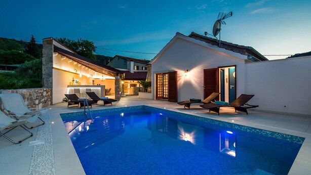 A modern villa with a swimming pool, outdoor seating, and a well-lit patio area. - Villa Jasmine (Stari Grad)