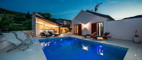 Piscine extérieure en saison, parasols, chaises longues