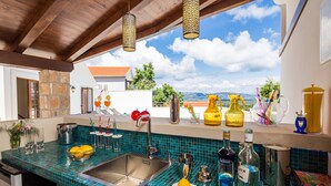 A kitchen with a blue tiled backsplash, stainless steel sink, and various kitchen items. - Villa Jasmine (Stari Grad)