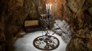 A candlelit alcove with a chandelier, a candelabra, and a wooden chest. - Villa Jasmine (Stari Grad)