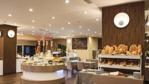 A modern breakfast buffet with various food items and a seating area. - Nevali Hotel (Sanliurfa)