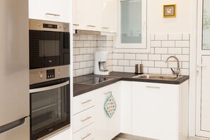 Appartement, 1 slaapkamer | Privékeuken | Een koelkast/vriezer, een magnetron, een oven, een kookplaat