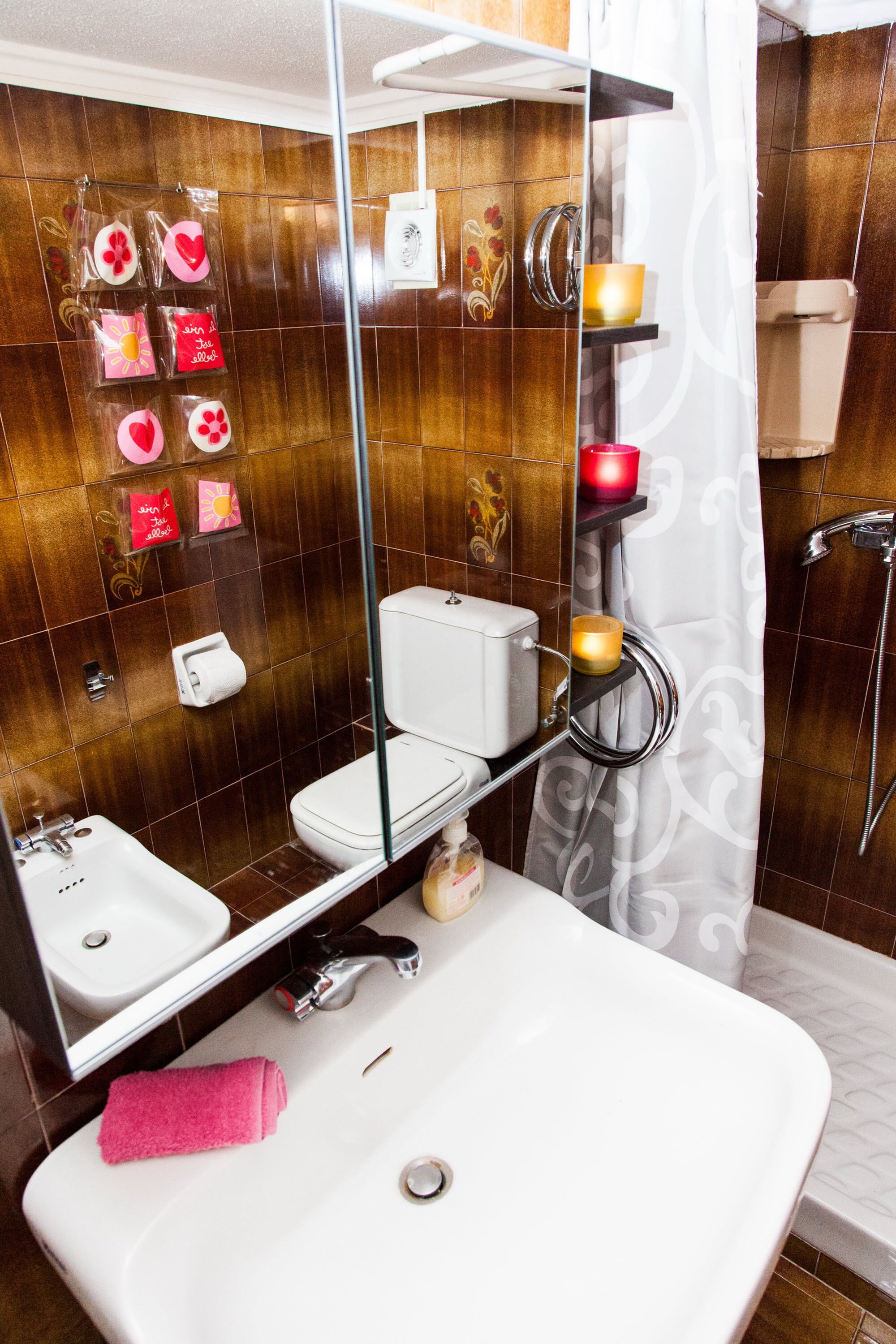 Et badeværelse med et hvidt håndvask, en brusekabine i glas og et toilet.