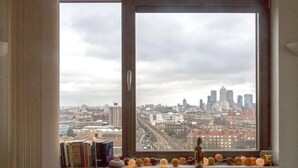A room with a large window overlooking a cityscape. - Centrally Located Spacious Flat (London)