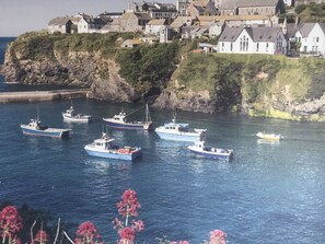 Une ville côtière où plusieurs bateaux de pêche sont amarrés près du rivage.