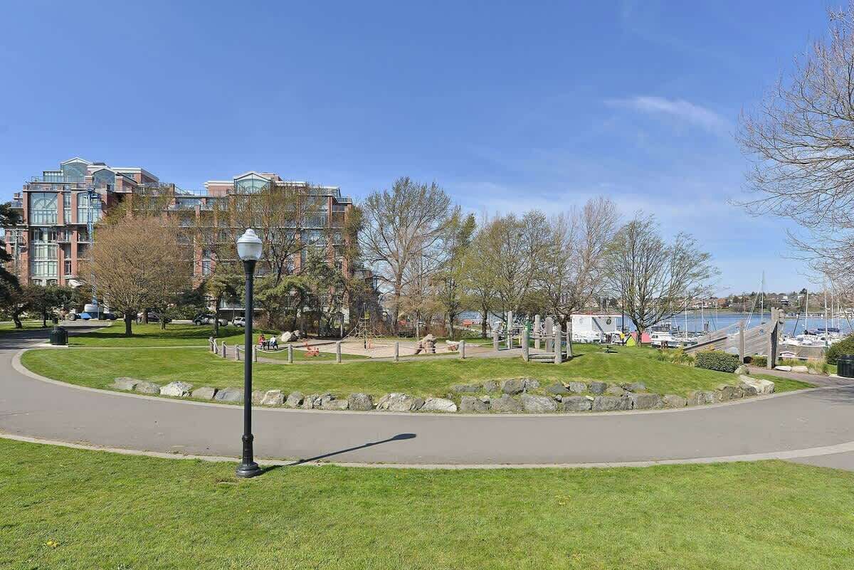 Un parc avec un chemin sinueux, des bancs et un lampadaire.