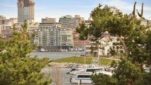 A marina with boats docked, surrounded by multi-story buildings and a river. - Harbourview Executive Condo (Victoria)