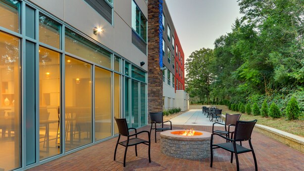 An outdoor patio with brick flooring, a fire pit, and outdoor seating. - Holiday Inn Express & Suites Roanoke – Civic Center by IHG (Roanoke)