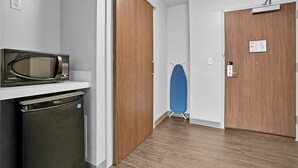 A compact kitchen with a microwave, dishwasher, and a wooden door. - Holiday Inn Express Jacksonville South Bartram Prk by IHG (Jacksonville)