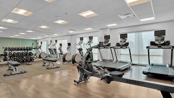 Una palestra con diverse attrezzature per l'esercizio fisico, tra cui tapis roulant e macchinari per pesi.