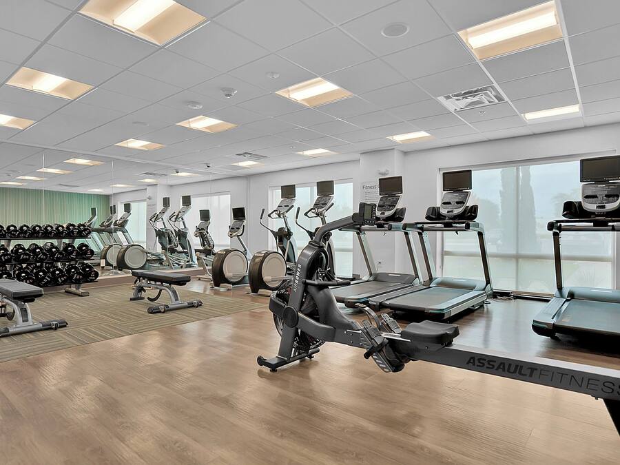 Una palestra con diverse attrezzature per l'esercizio fisico, tra cui tapis roulant e macchinari per pesi.