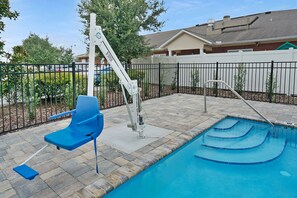 A swimming pool with a blue chair and a pool lift. - Holiday Inn Express Jacksonville South Bartram Prk by IHG (Jacksonville)