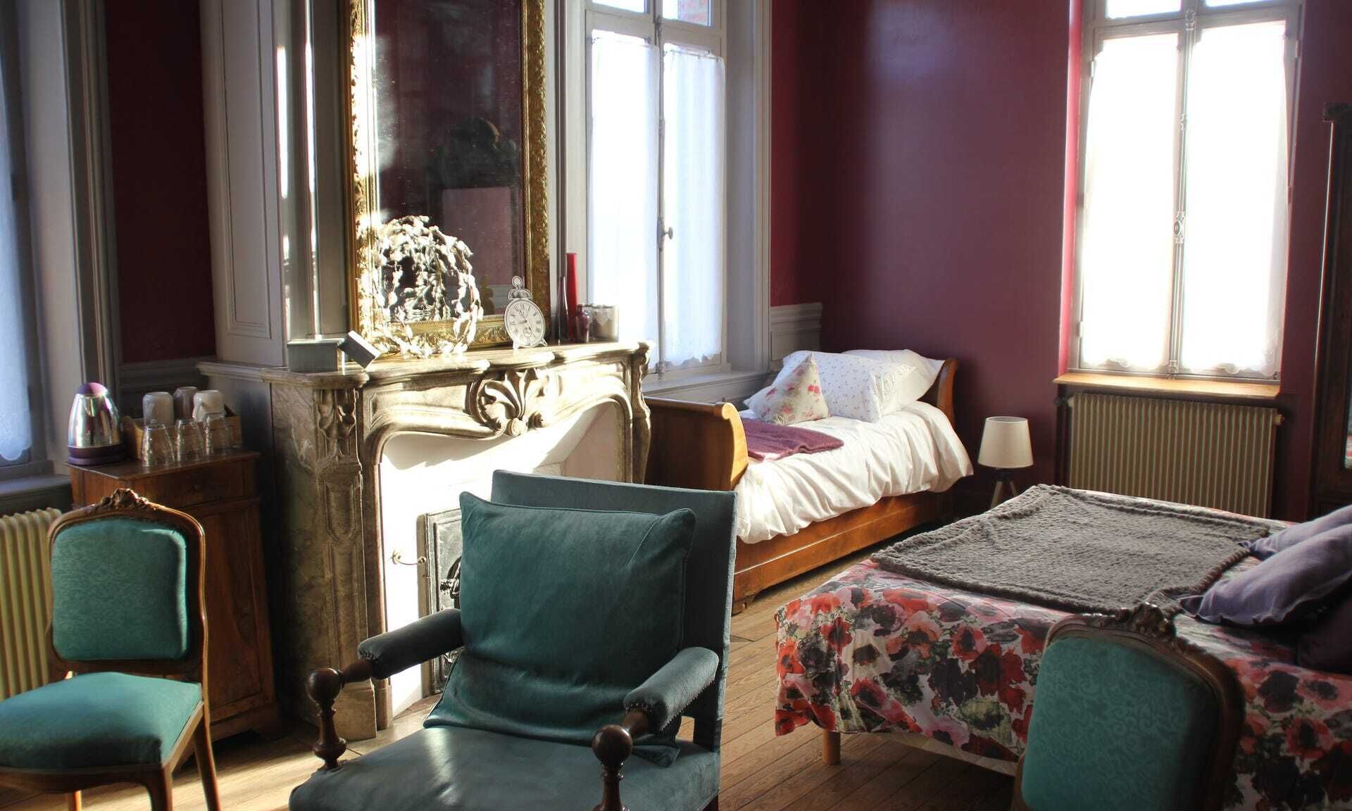 A room with a bed, a chair, a table, and a dresser.
