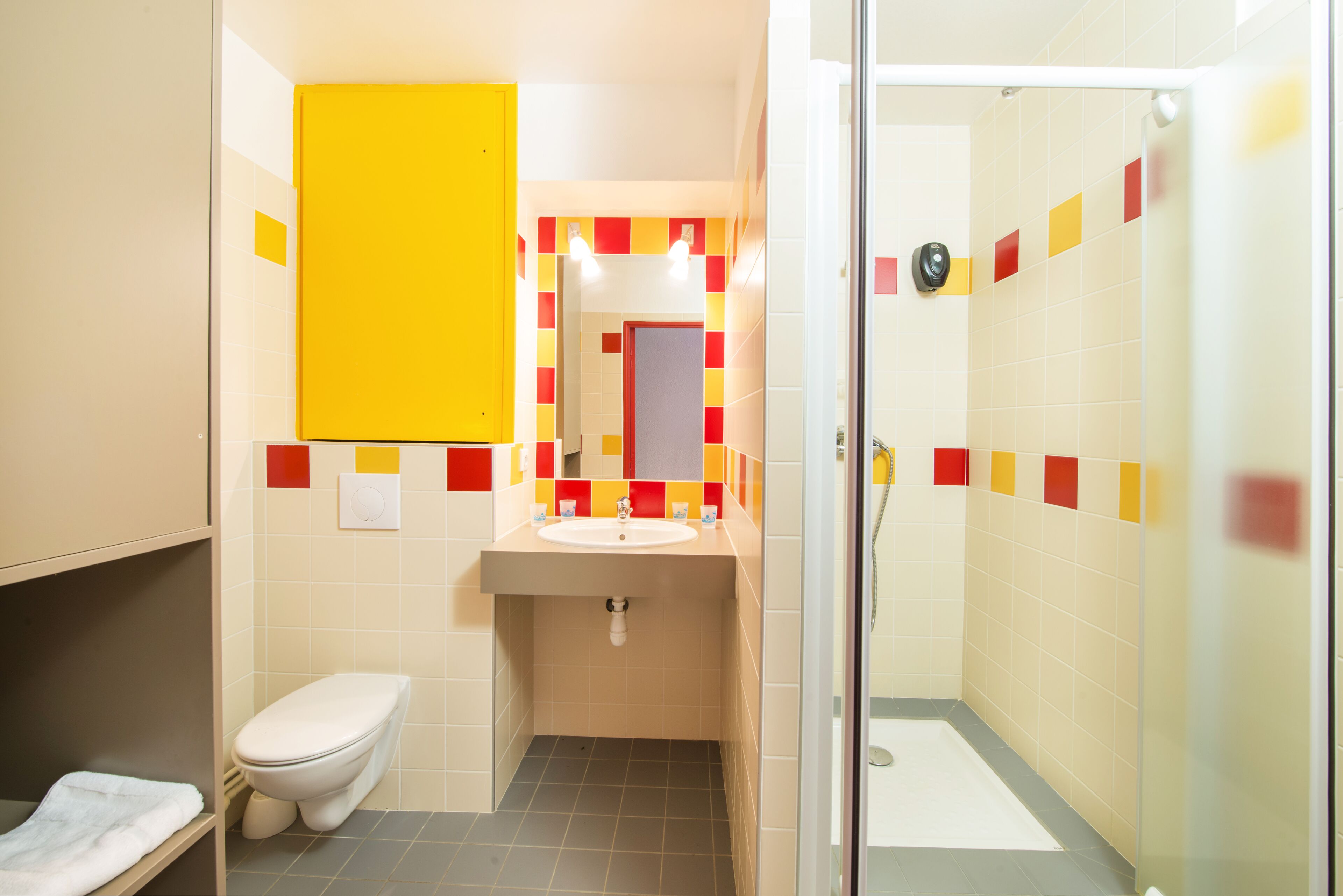 A small bathroom with a toilet, sink, and shower.