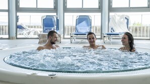 Un bain à remous où se trouvent trois personnes.