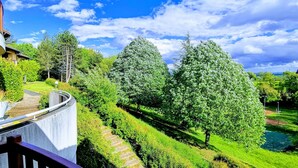 Un jardin aménagé avec des haies taillées avec soin, un chemin sinueux et une variété d’arbres.