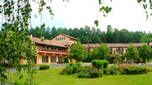Un hôtel composé de plusieurs bâtiments, doté d’une pelouse bien entretenue et offrant une vue sur un ciel dégagé.