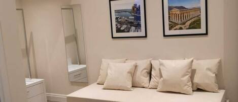 Una camera da letto moderna con un letto grande, uno specchio e due quadri appesi al muro.