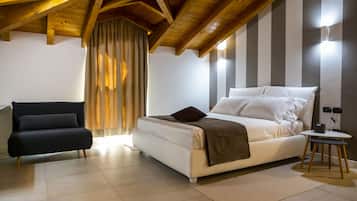 Relax in this stylish bedroom with a large bed, sofa, and natural light pouring in through the large window.