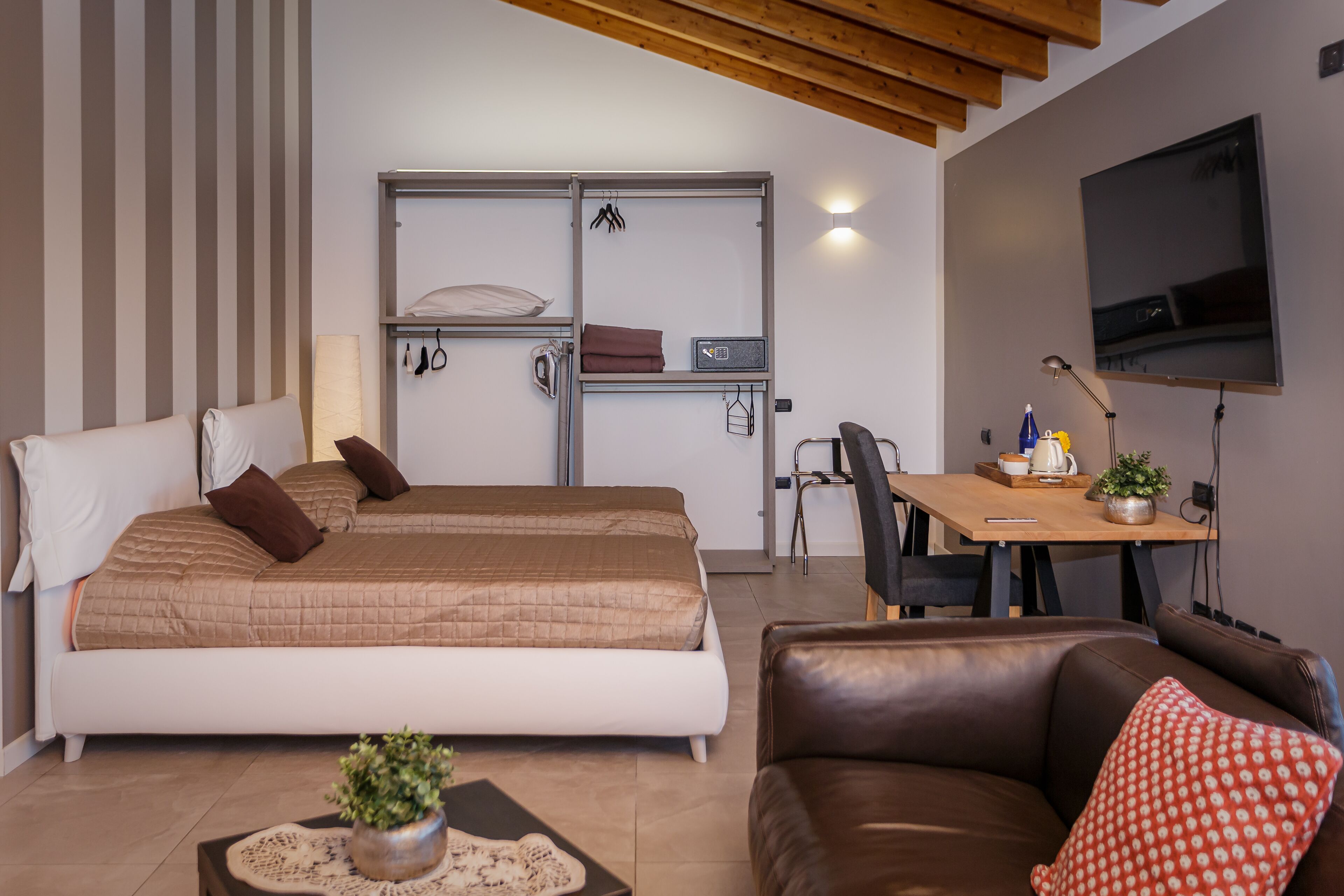 Una camera da letto moderna con un letto grande, una scrivania e un televisore.