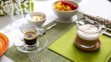 Ein Tisch mit einer Kaffeetasse, einer Obstschale und einem Teller Essen.