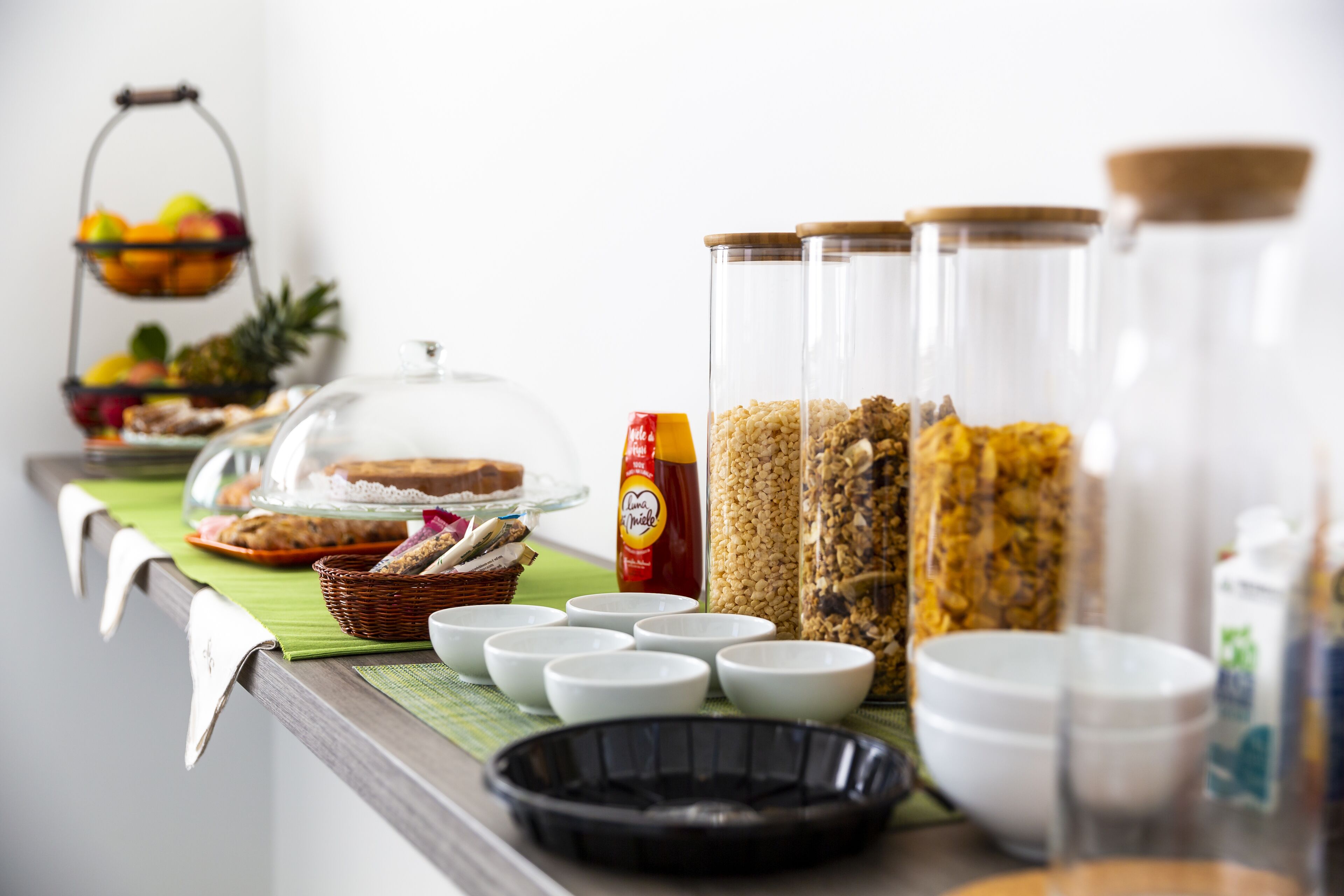 Disposição de buffet com diversos alimentos e recipientes.
