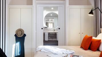 Un dormitorio con cama, mesita de noche, espejo y armario.