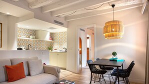 Ein modernes Wohnzimmer mit Sofa, Couchtisch und Essbereich mit Stühlen.