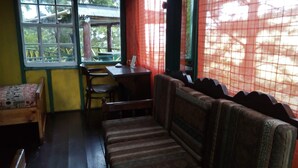 Una habitación con un banco de madera, una mesita y una silla.