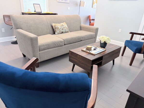 A living room with a sofa, a coffee table, and two chairs.