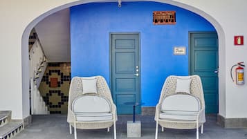 Een blauwe deur met een bordje waarop 'Frida' staat en een brandblusser aan de muur.