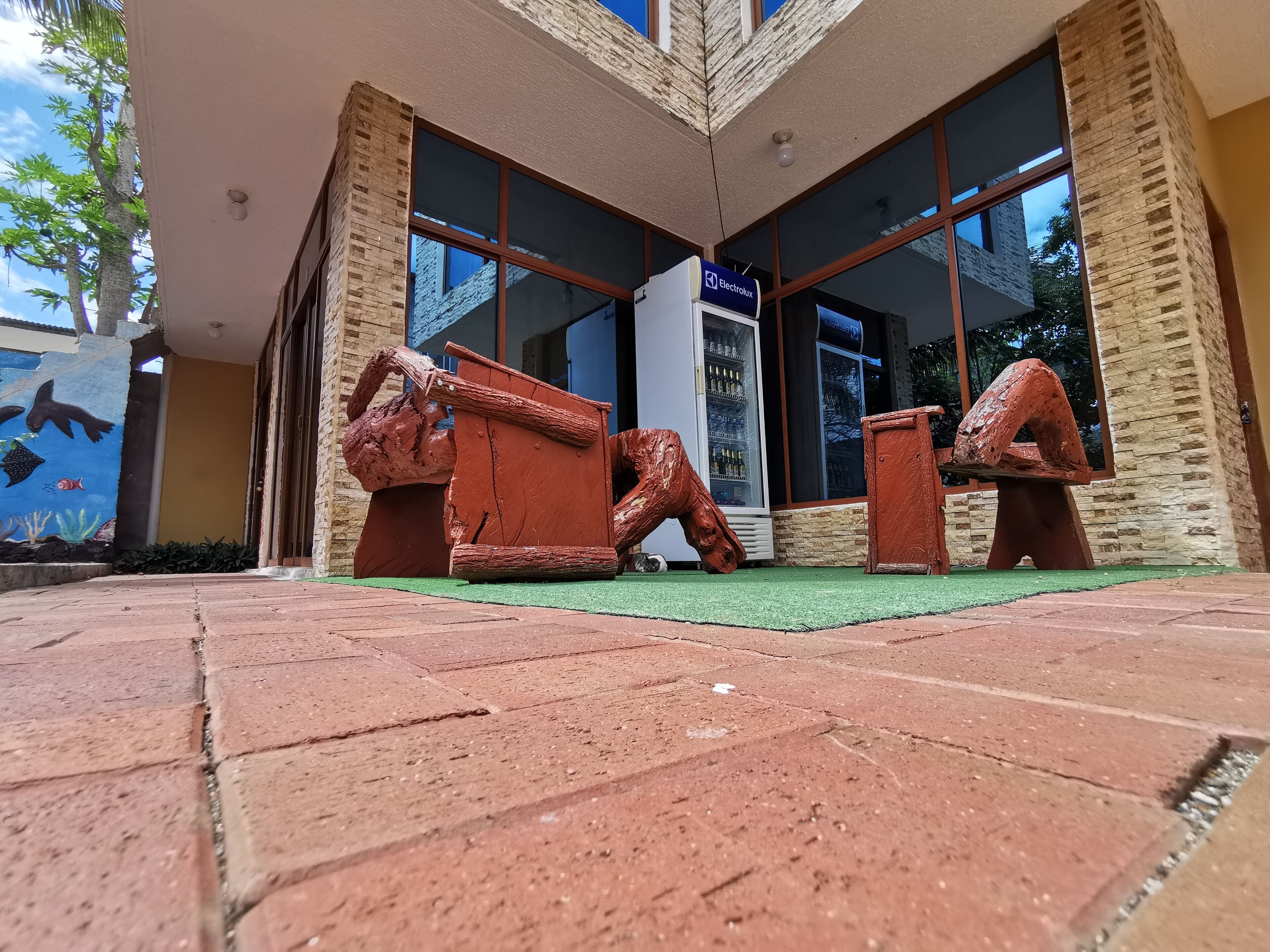 A building entrance with a brick facade, large windows, and a mural of sea creatures.